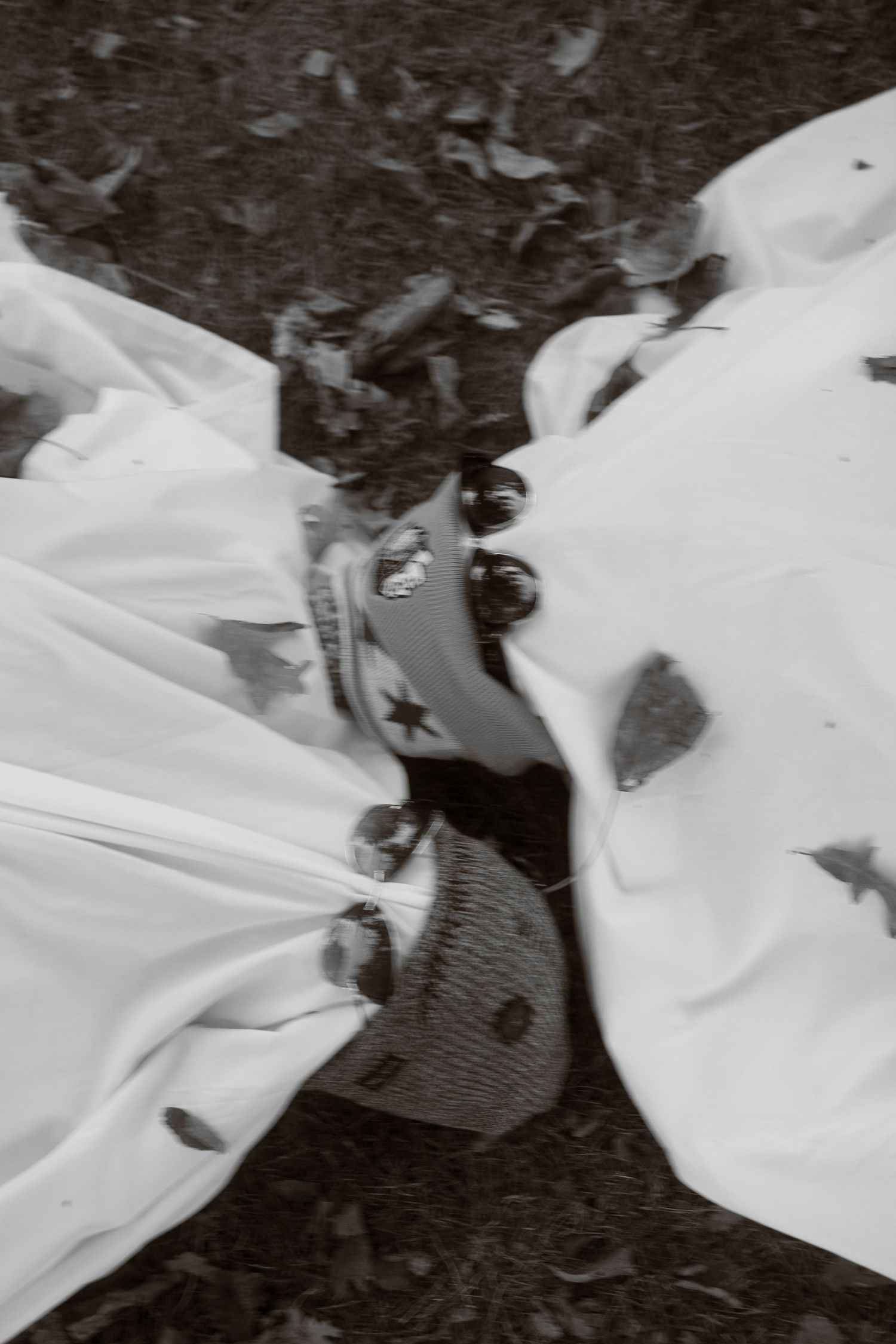 White ghost costumes with star decorations lay scattered on dark ground.