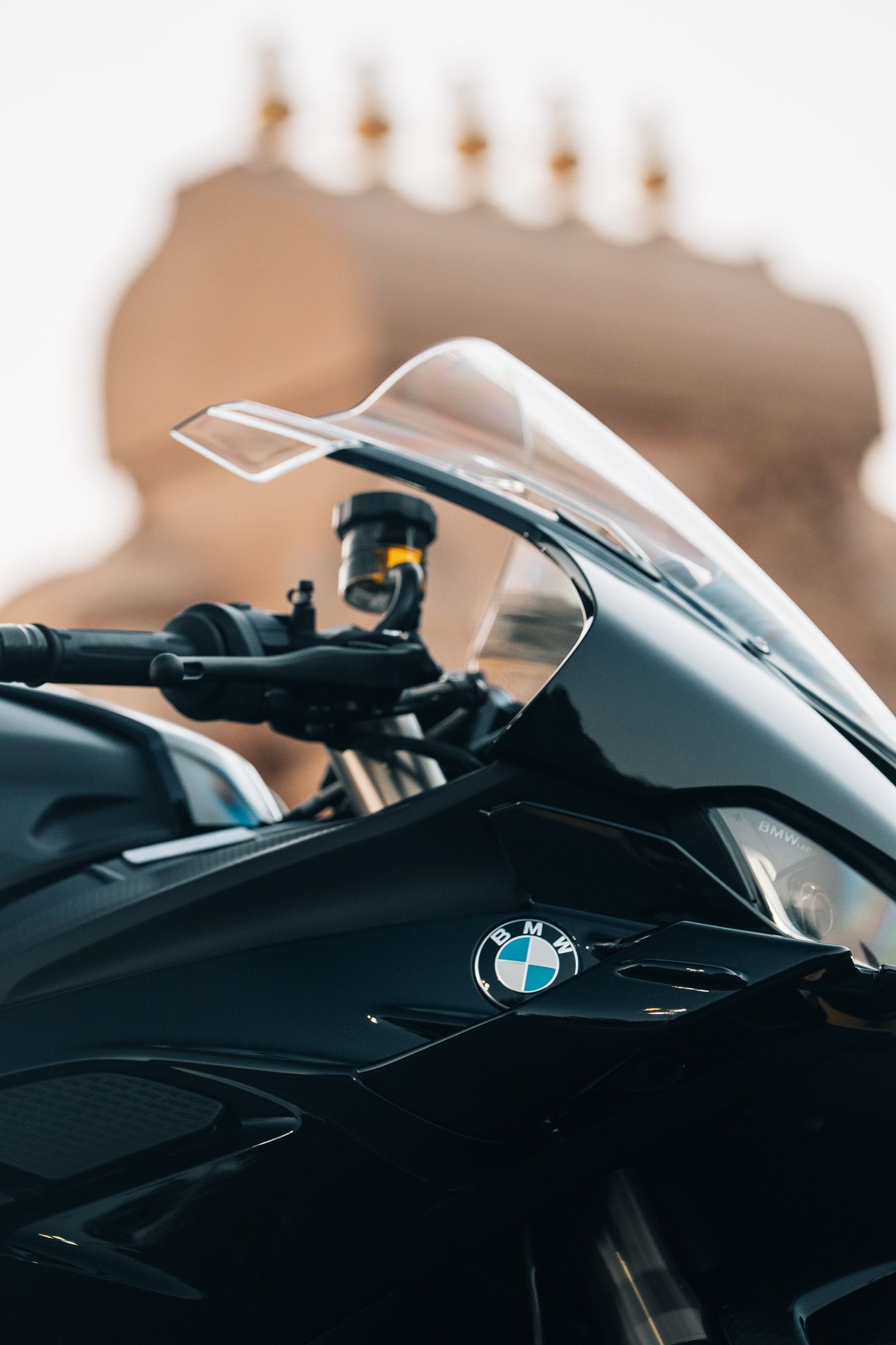 Close-up detail of a black BMW motorcycle's sleek fairing and logo.