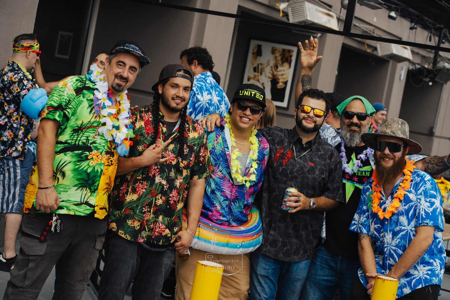 Group wearing colorful Hawaiian shirts posing together at an indoor event.