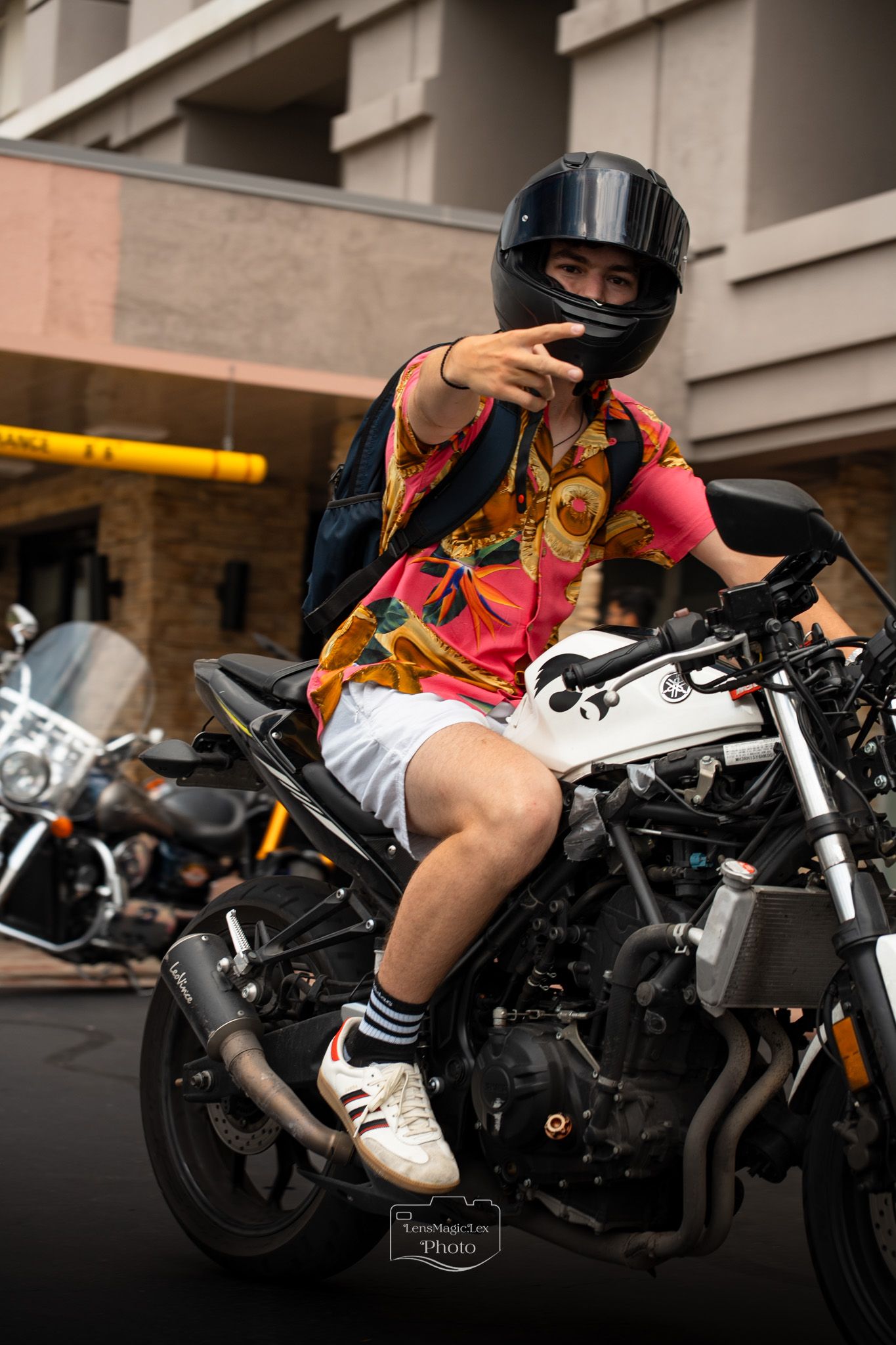 Motorcycle rider in a red outfit and helmet leans into a turn on a black sports bike.