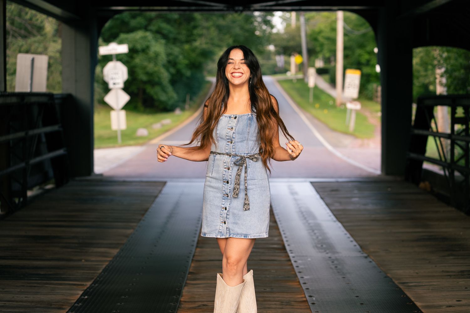 Denim dress and boots fashion photography on a covered bridge.