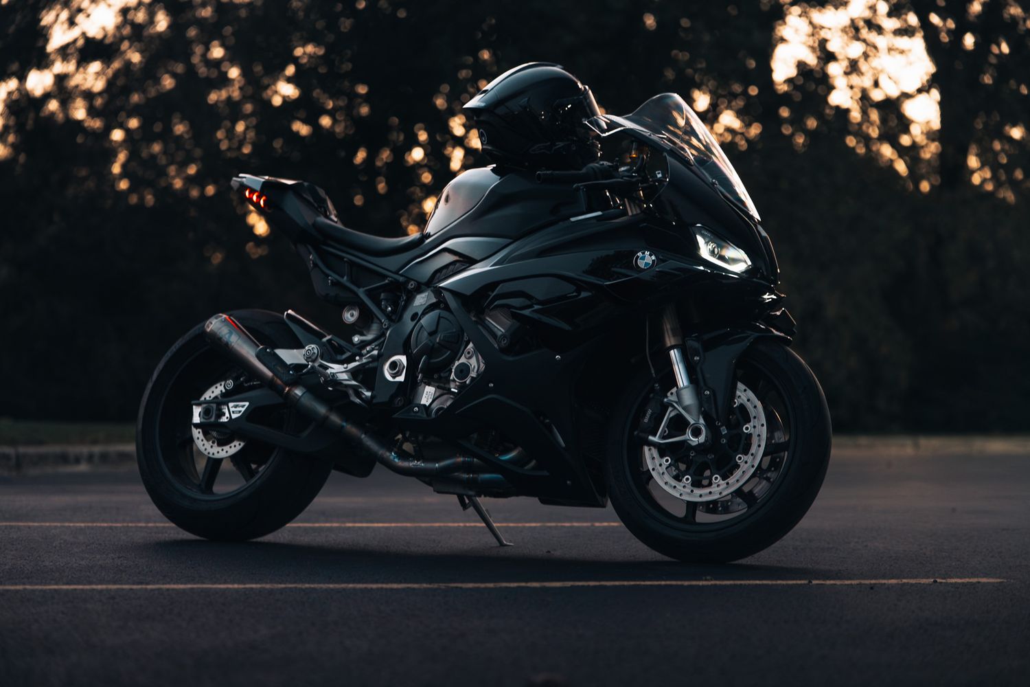 Silhouette of a BMW motorcycle at sunset with moody lighting.
