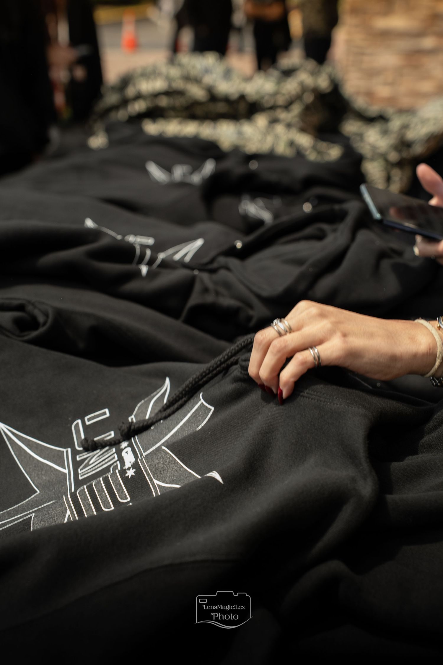Black fabric with white graphic designs laid out on a dark surface.