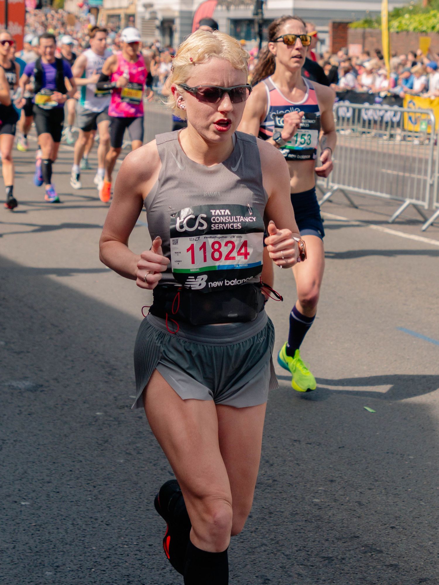 Runner wearing bib number 11824 competing in a marathon race on a sunny day, with other runners visible in the background.