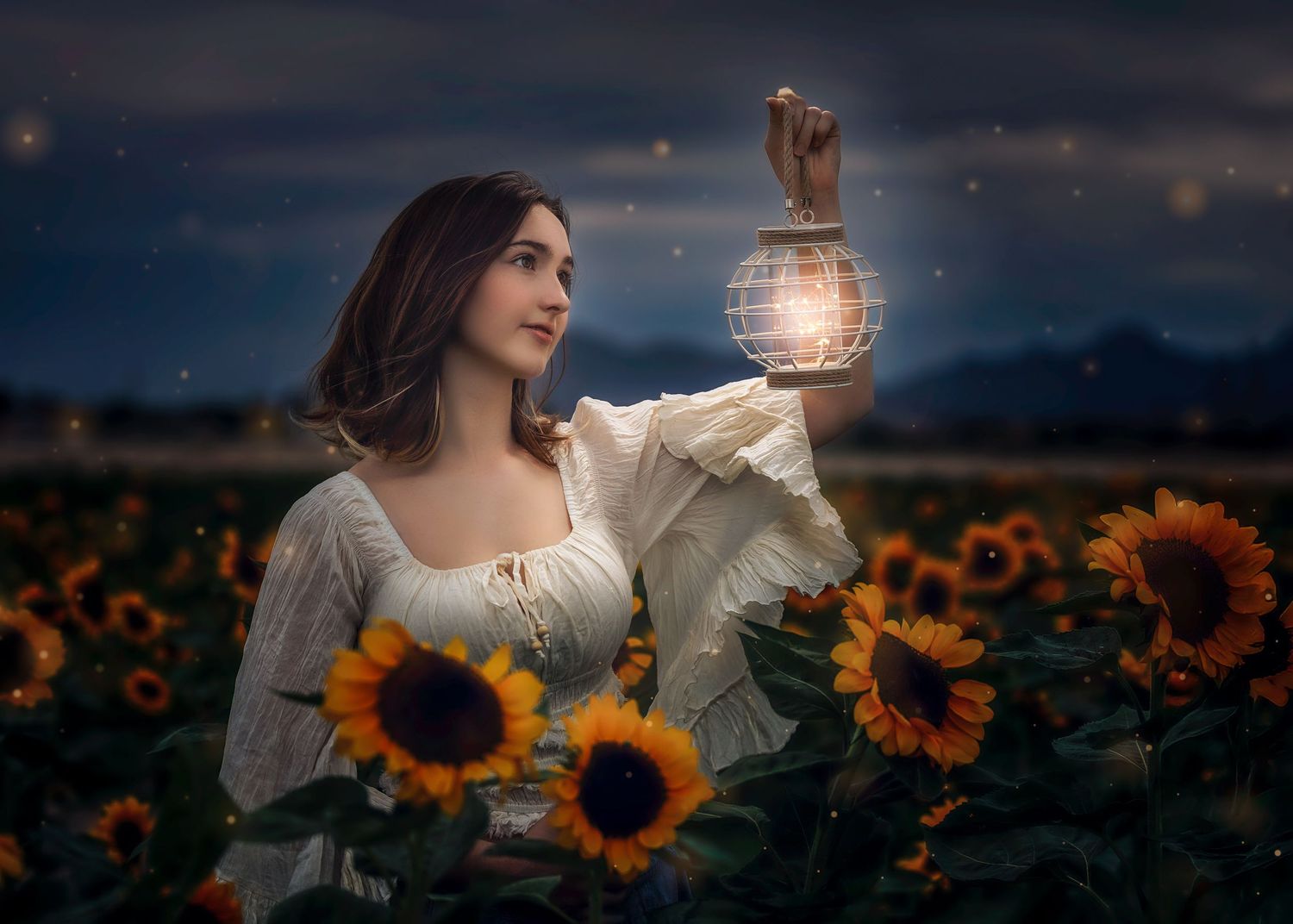 Young woman in white dress holding glowing lantern in sunflower field at dusk with fireflies.