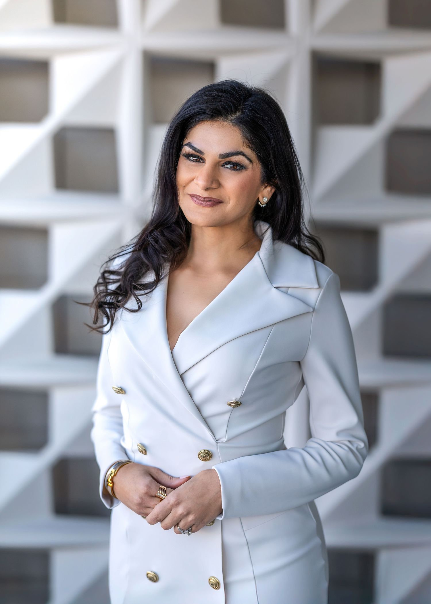 Corporate woman and leader smiling in front of her office plaza.