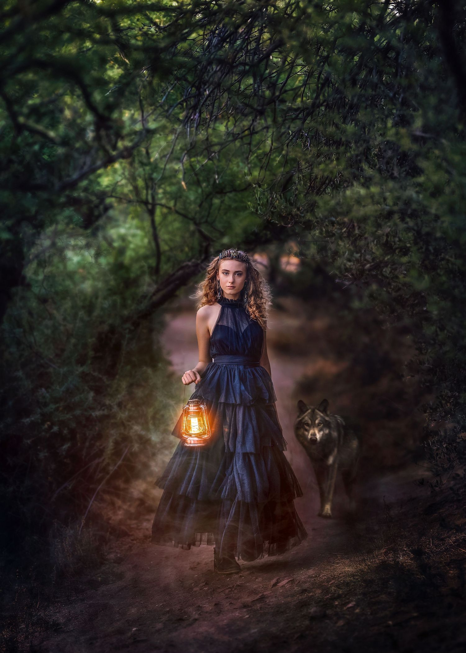 Woman in dark gown holding glowing lantern walks forest path with wolf following behind at dusk.