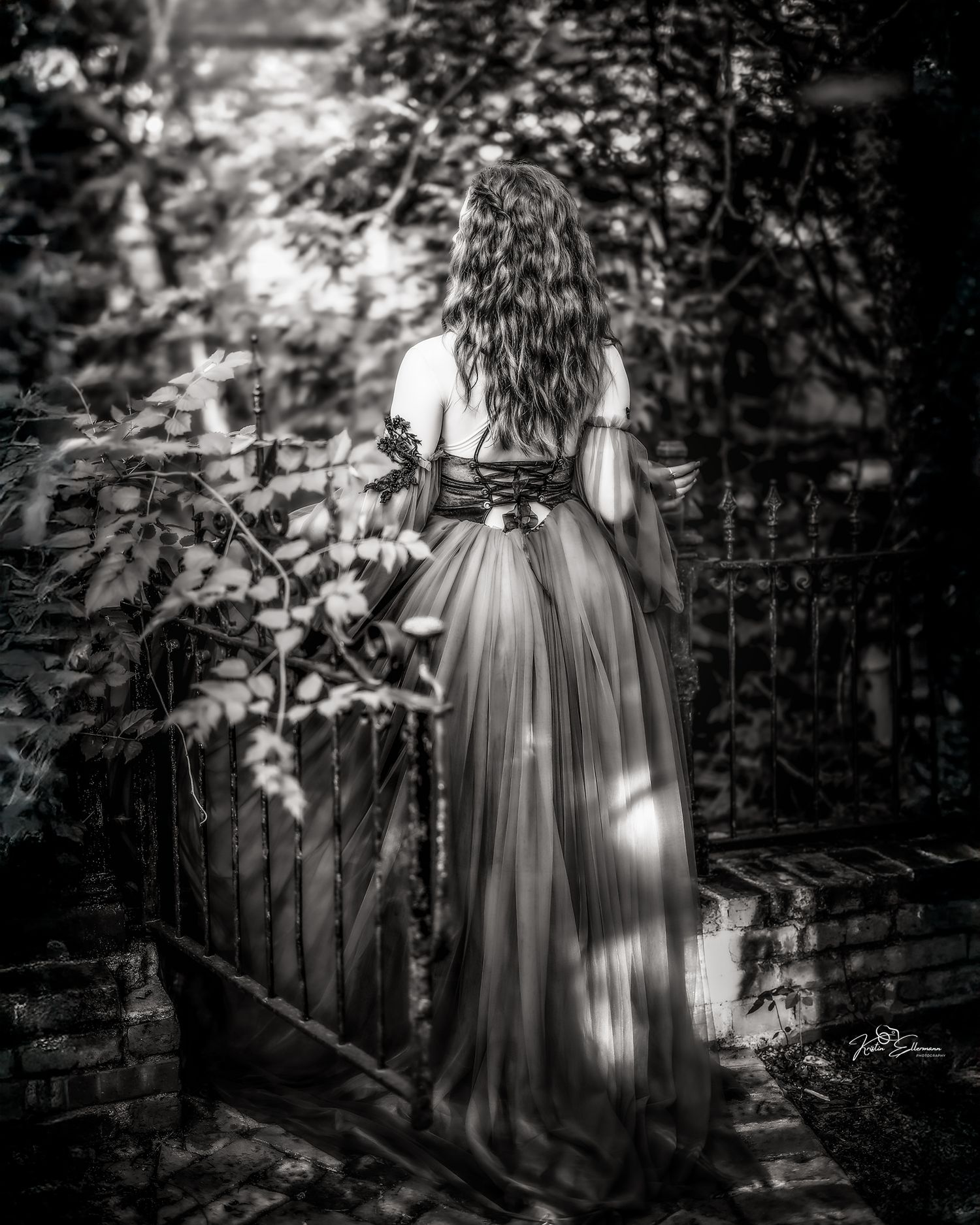 Black and white fine art portrait of a young woman beneath towering trees in Scottsdale, Arizona.