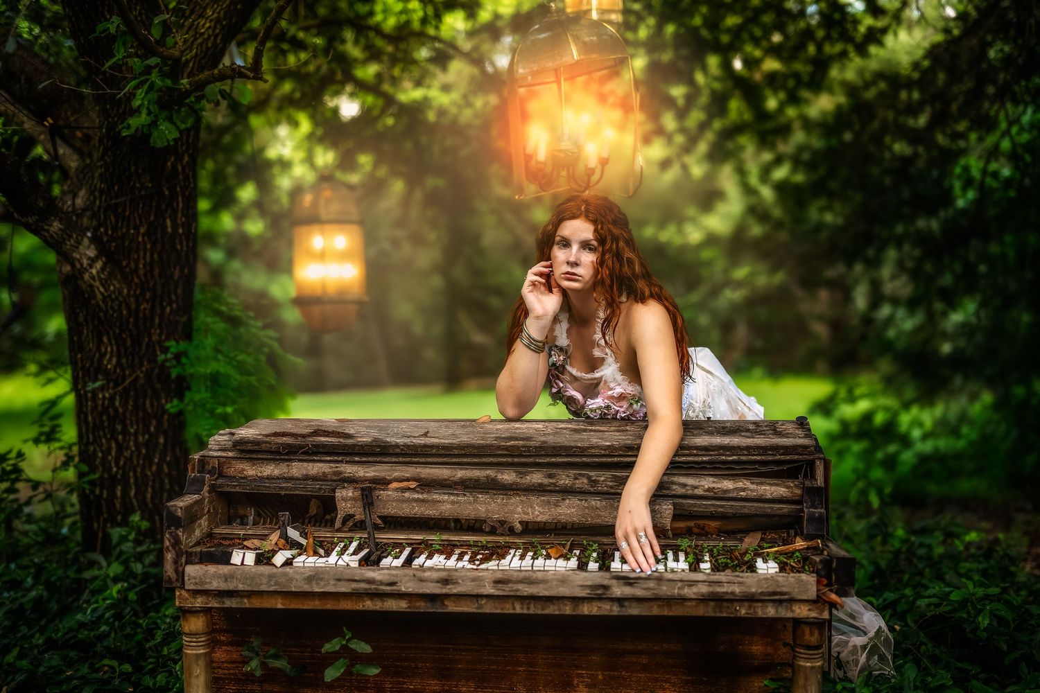 A pensive woman with curly hair leans on a rustic outdoor piano surrounded by lush green trees and glowing lanterns.