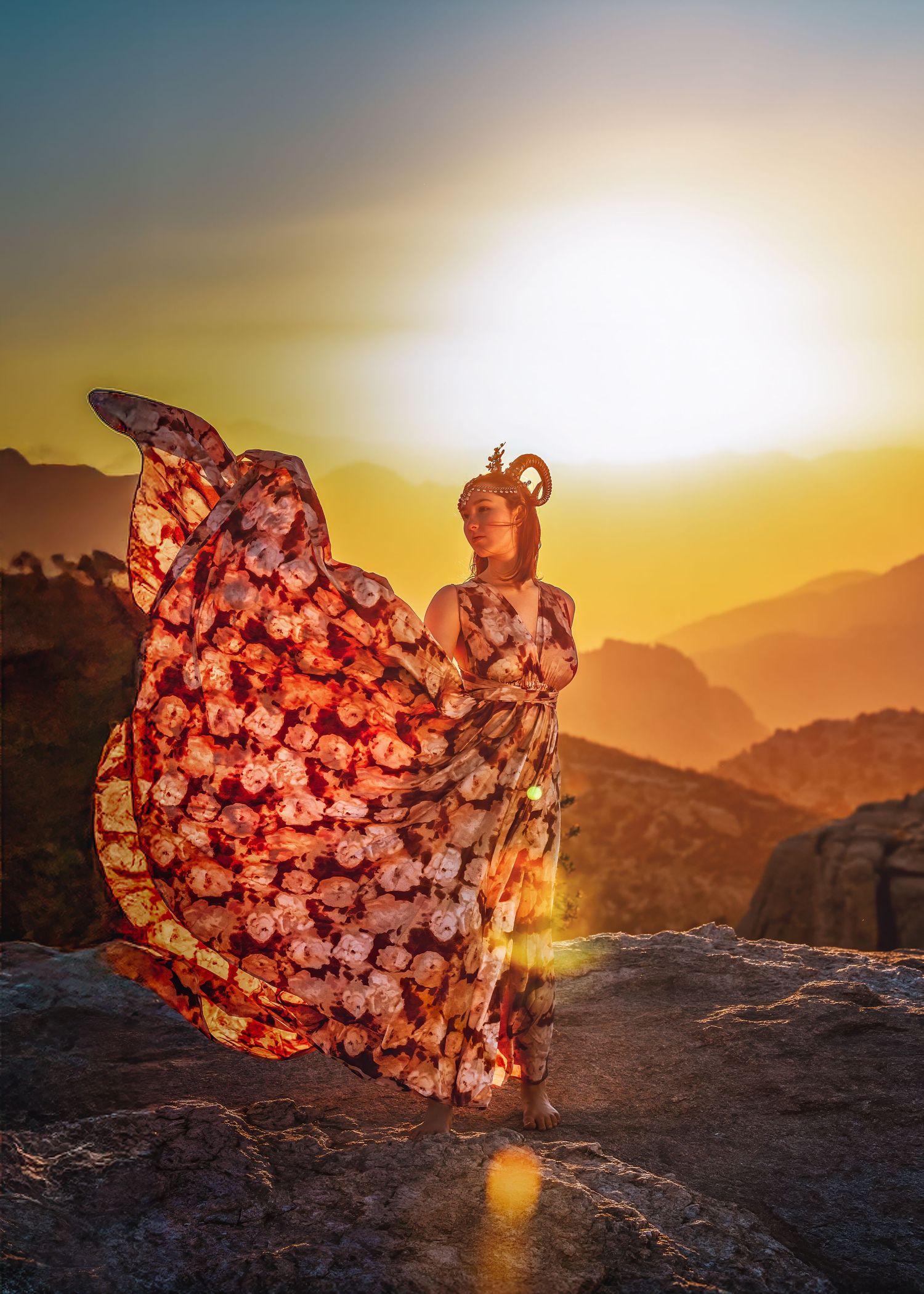 Elegant woman in floral dress twirling on rocky mountain summit during vibrant golden sunset.