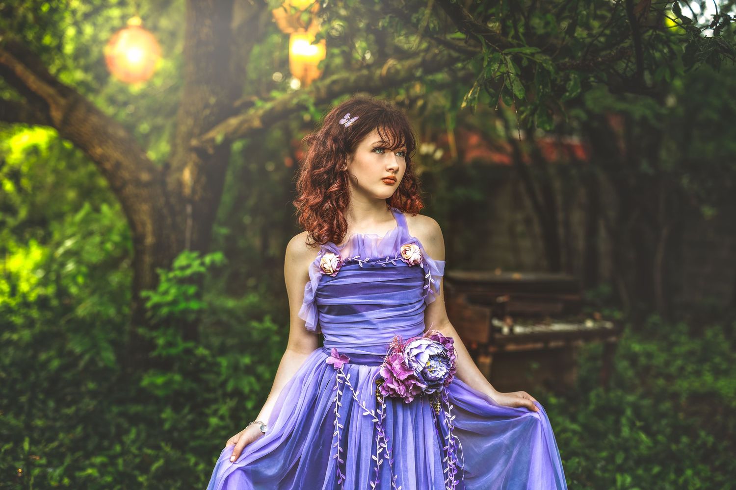 Whimsical fine art portrait of a teen girl in a lavender gown surrounded by glowing forest light in Arizona.