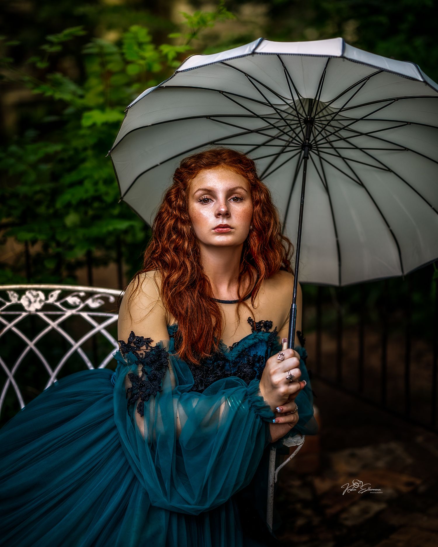 Fine art portrait of a young woman with a vintage umbrella in a lush Arizona garden by Kristin Ellermann.