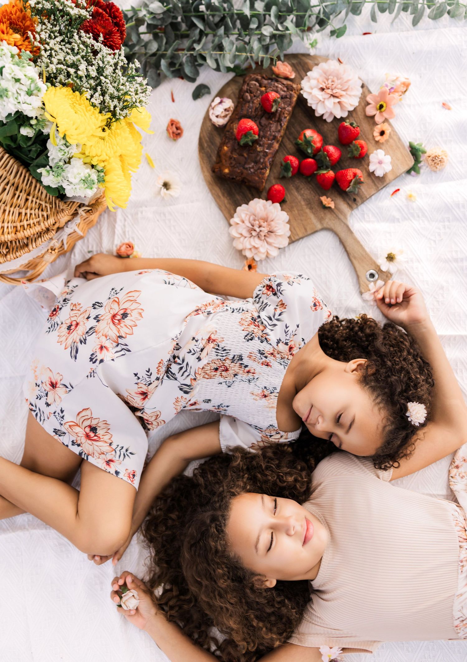 two sisters lay on a blanket