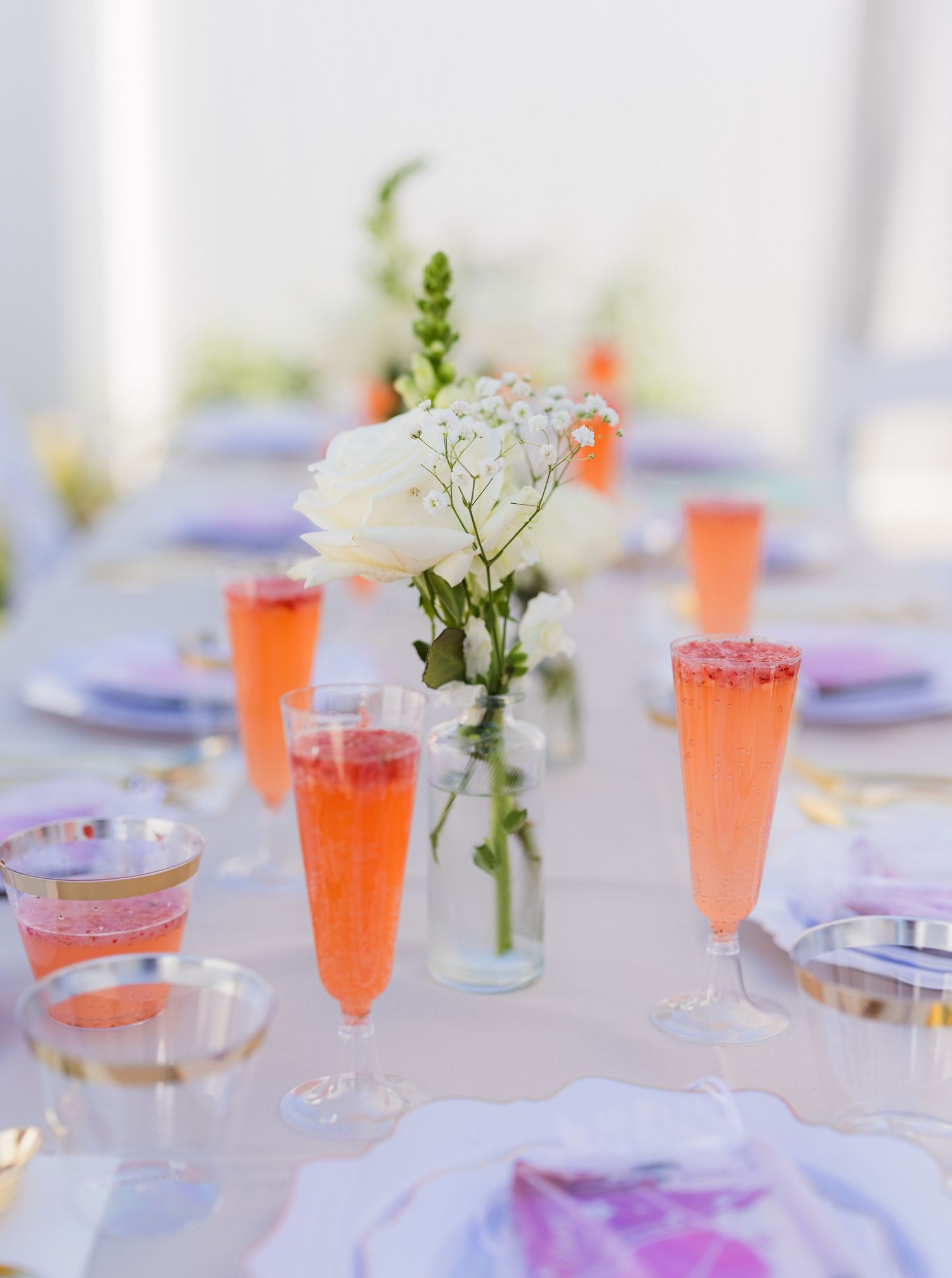 table setting with orange drink and white flowers