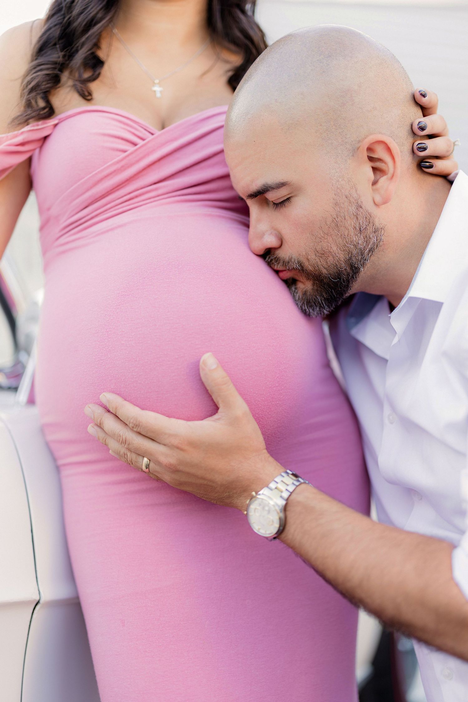 man kisses belly of pregnant wife