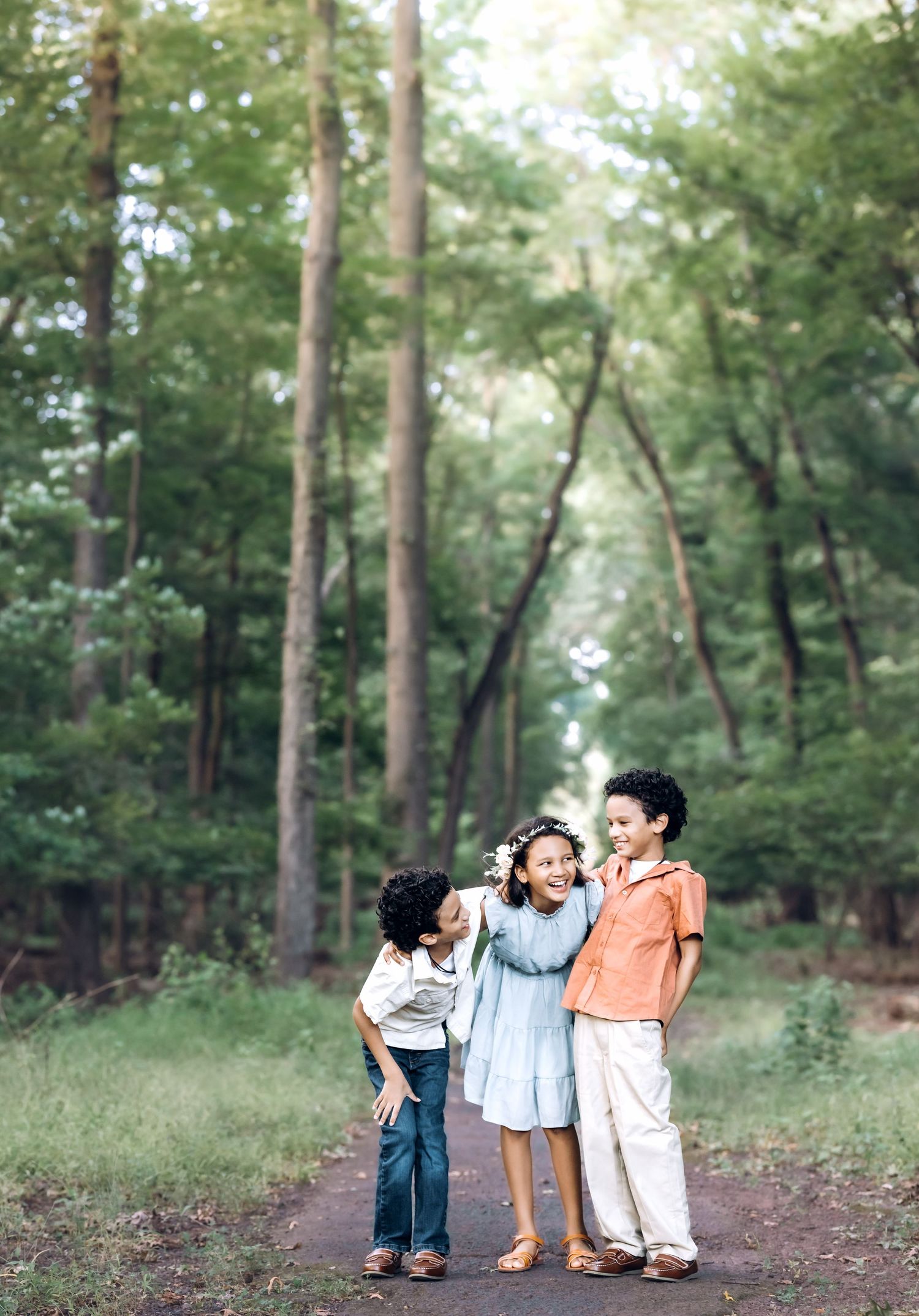 three children laugh in a forest