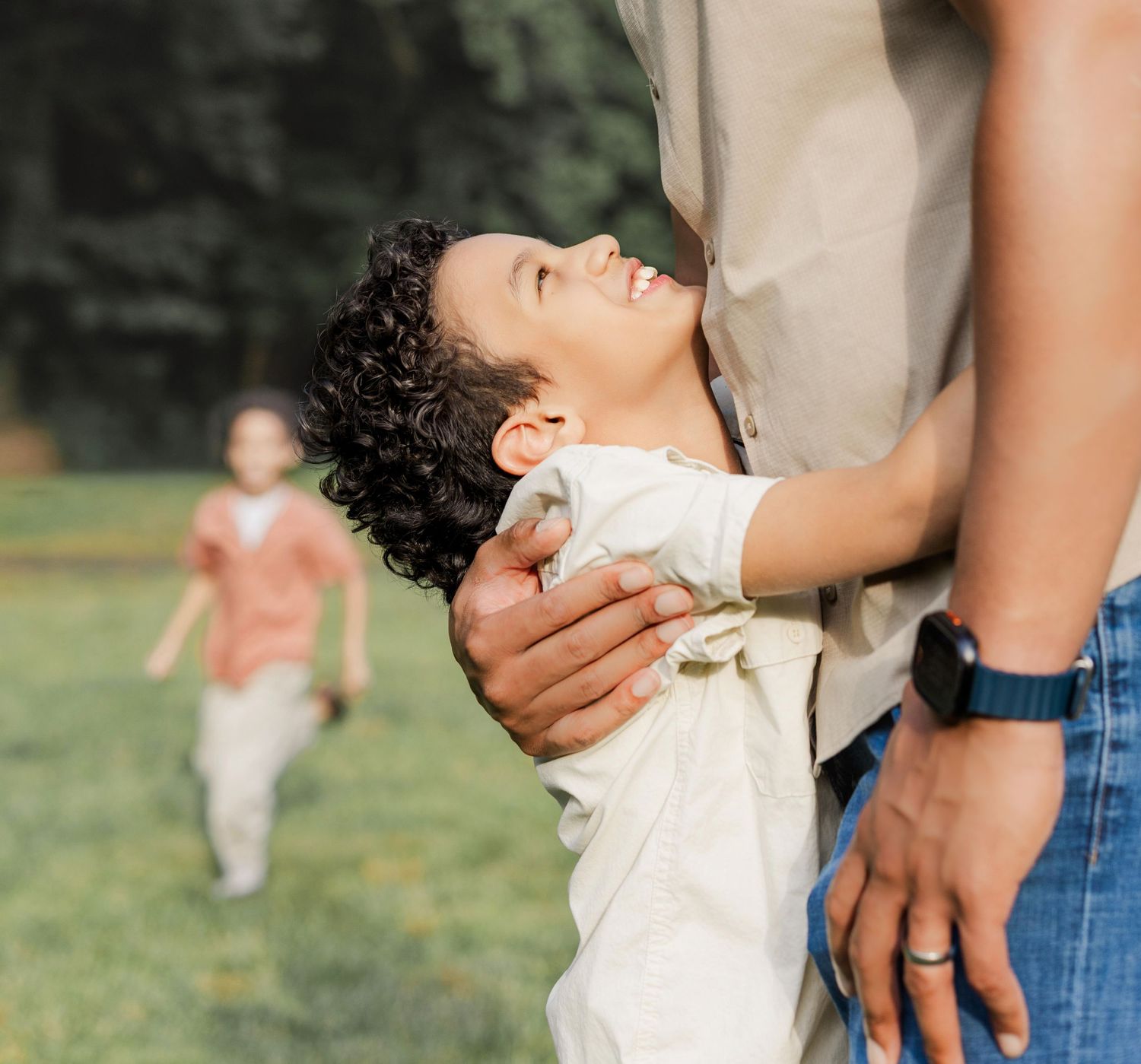 son hugs father and holds onto him while gazing upwards.