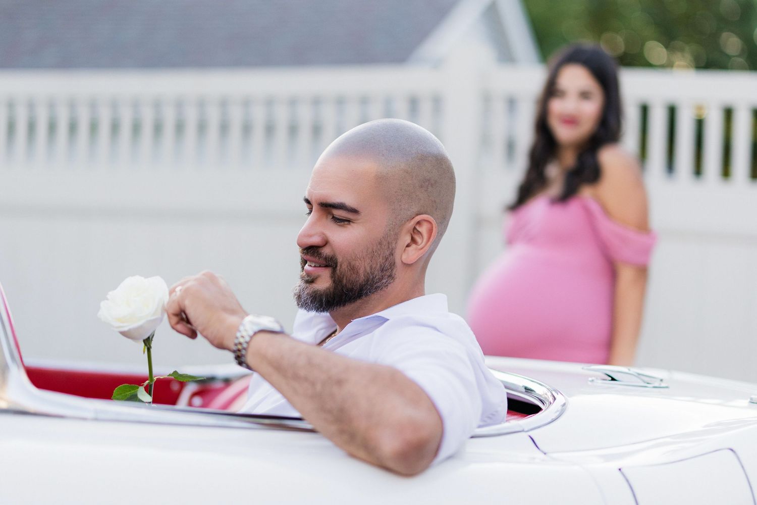 man picks flower with wife in background