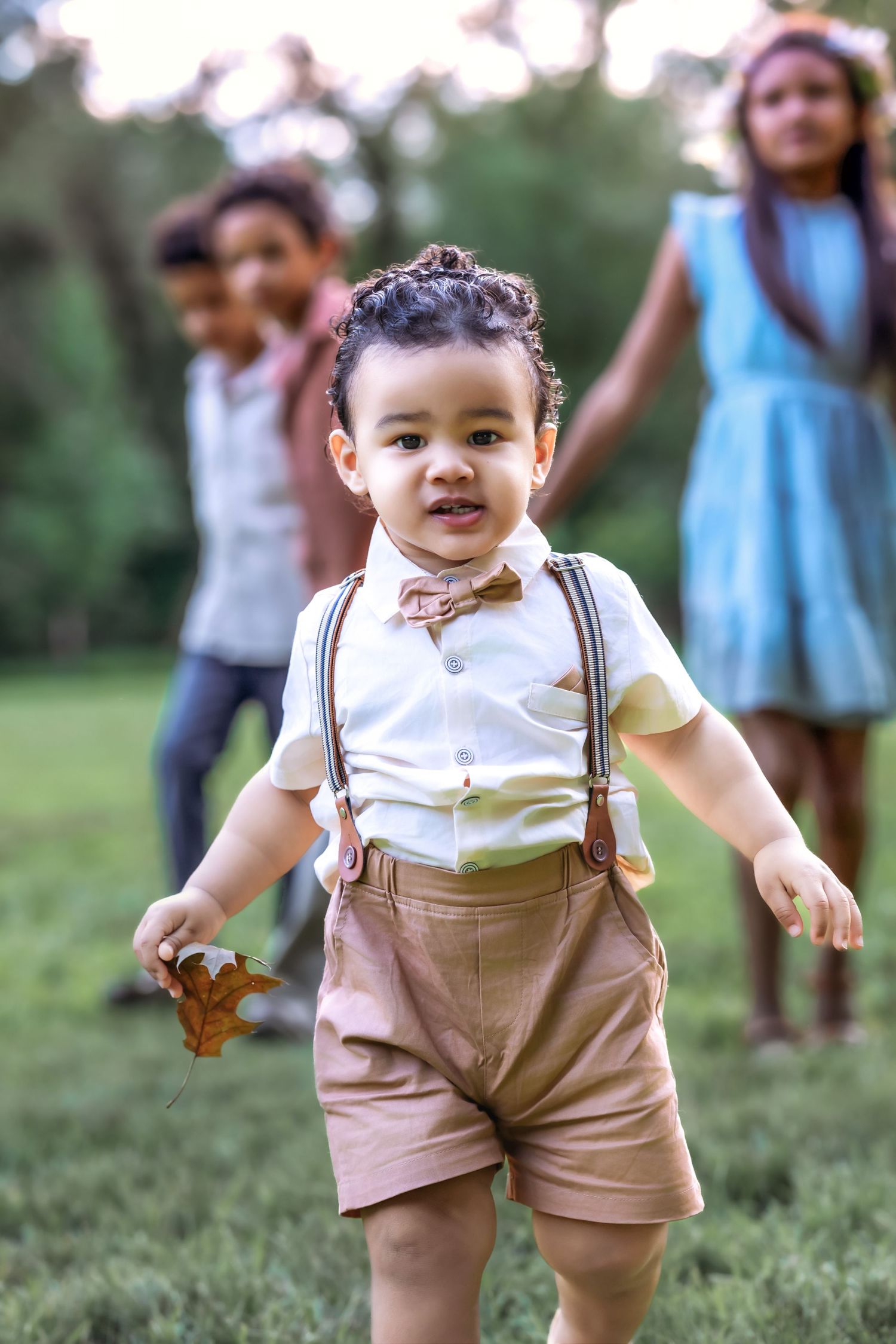 baby runs towards camera with his older three siblings behind him
