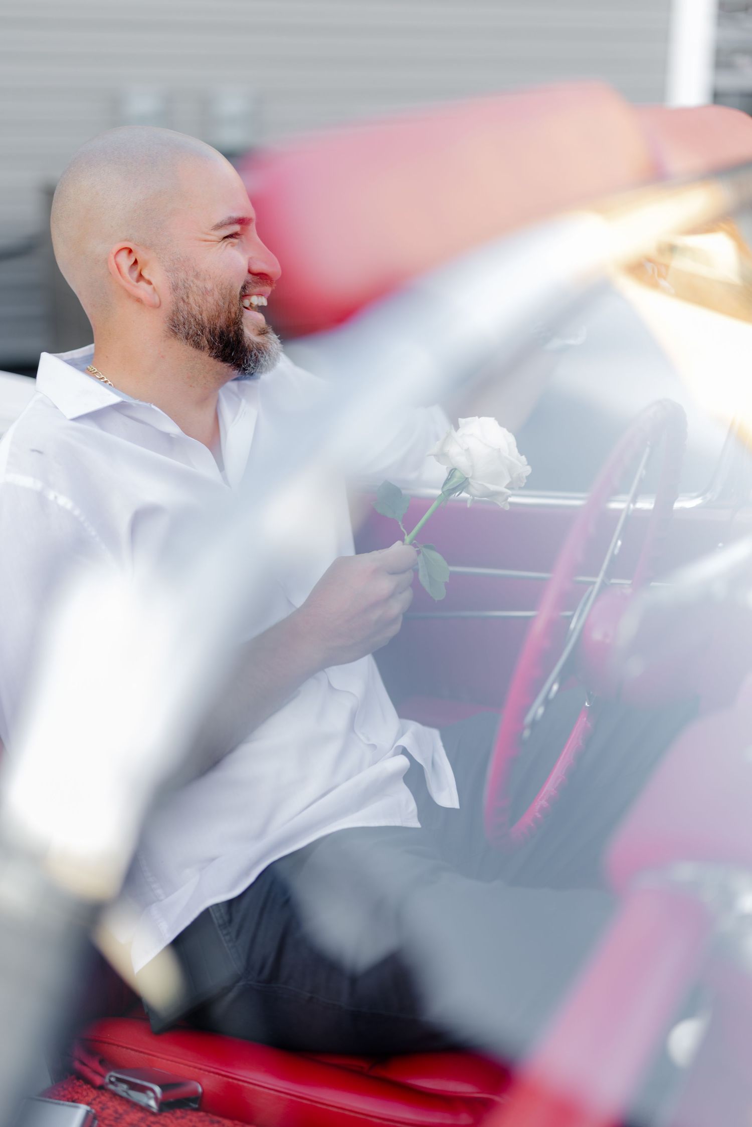 man in classic car laughing