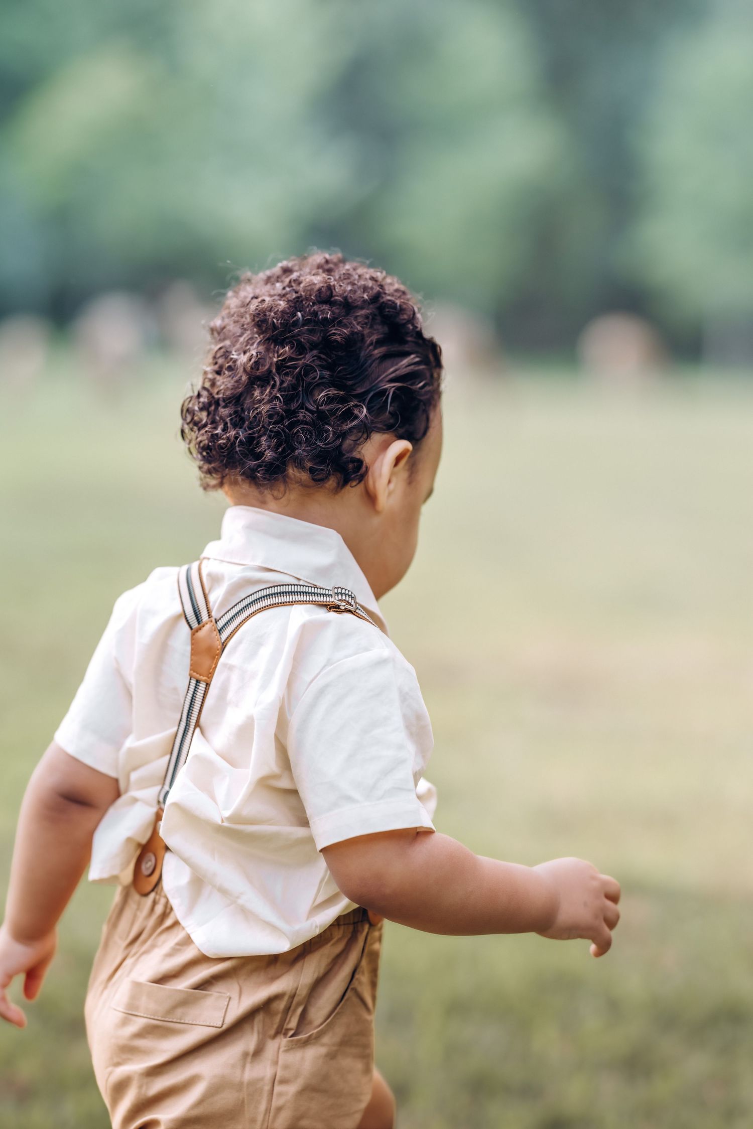 boy walks away in a field