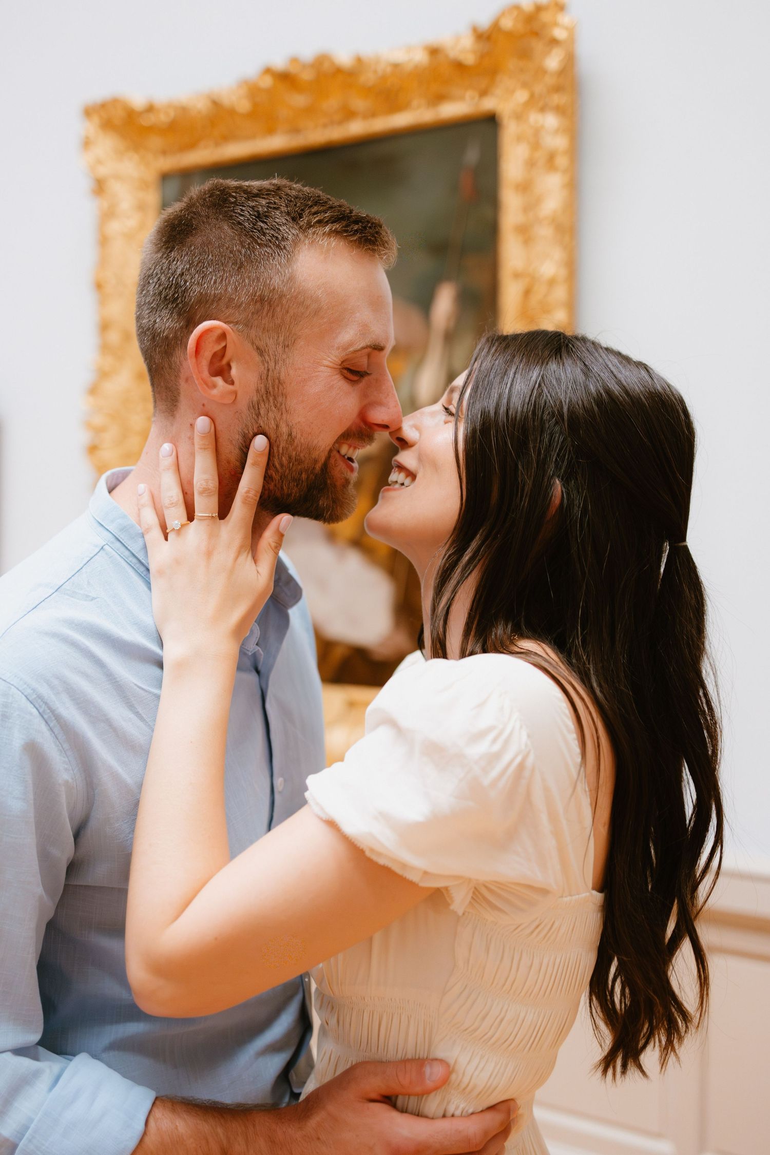 A couple shares a romantic sequence of intimate kisses while embracing in a warmly lit indoor setting.