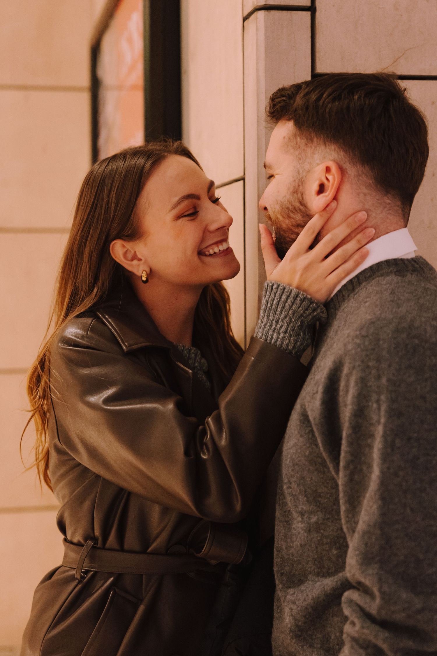 A couple in gray sweaters sharing intimate romantic moments in a warmly lit setting.