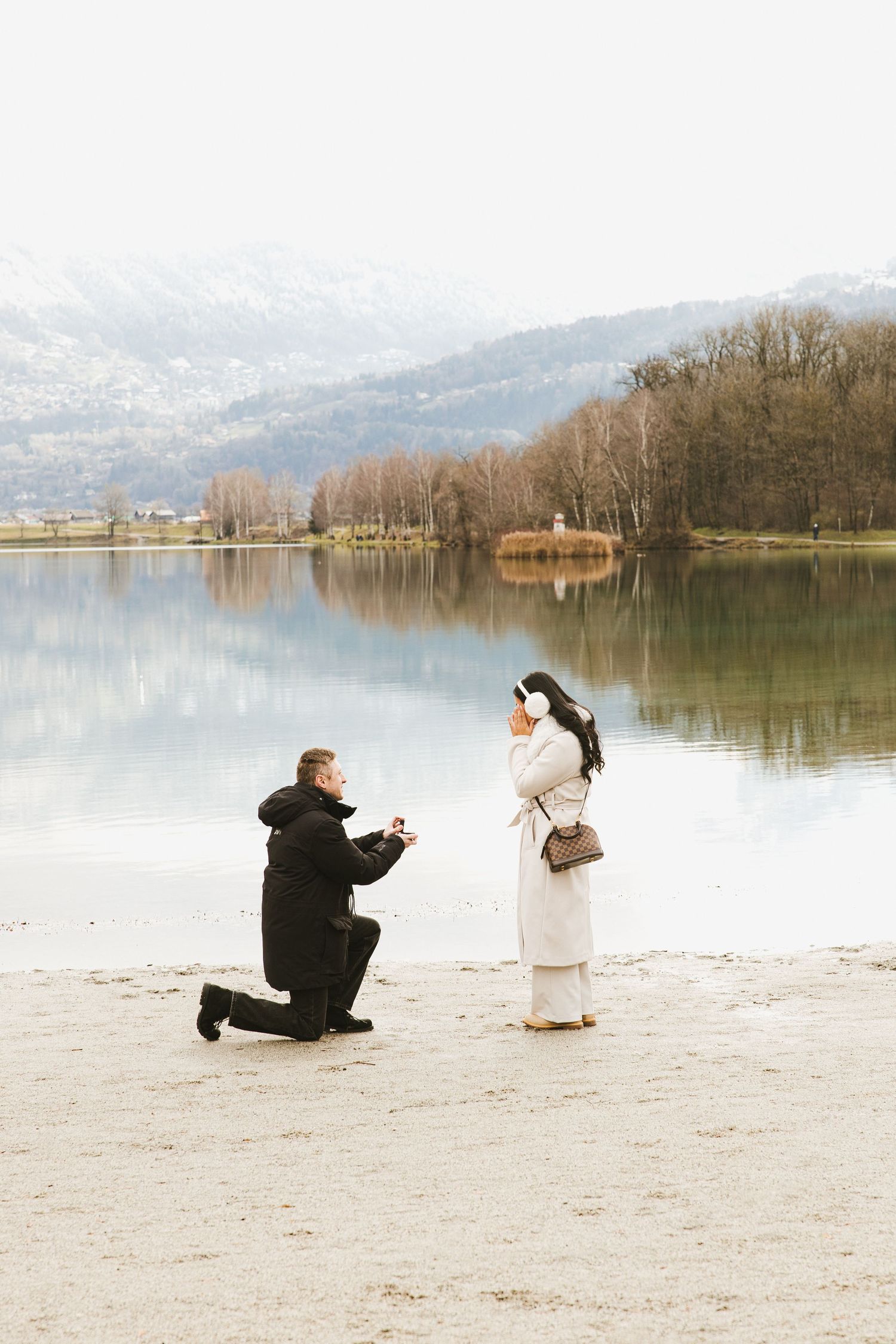 A series of proposal photos showing a couple on a lakeside beach with mountains and trees in the background.