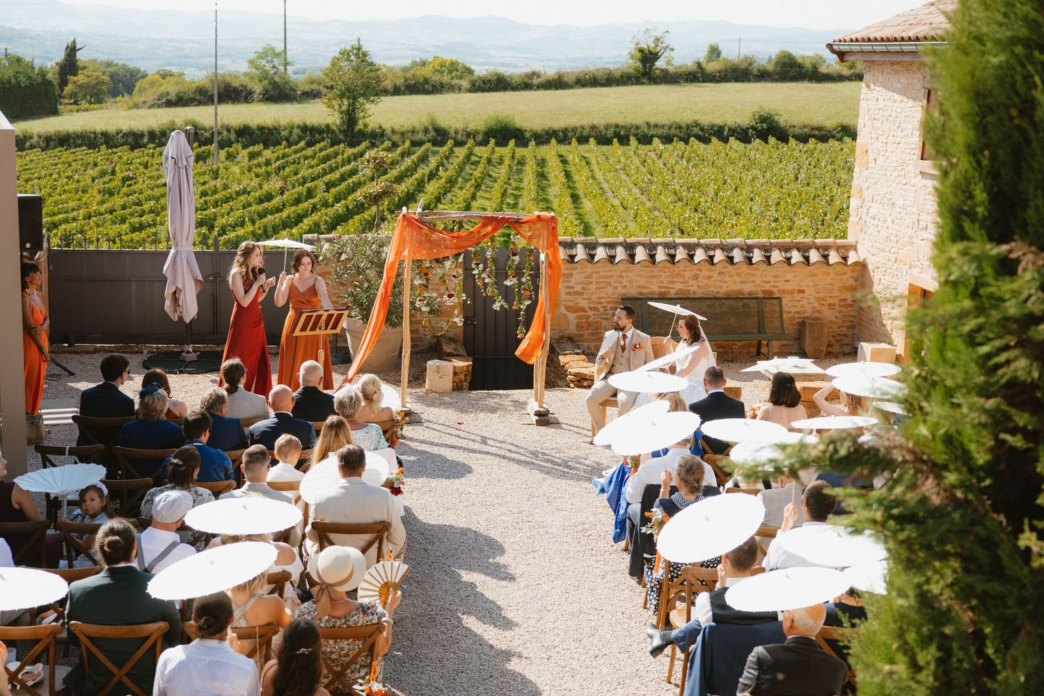 Guests enjoying wine and views on a sunny terrace overlooking scenic vineyard landscapes in wine country.