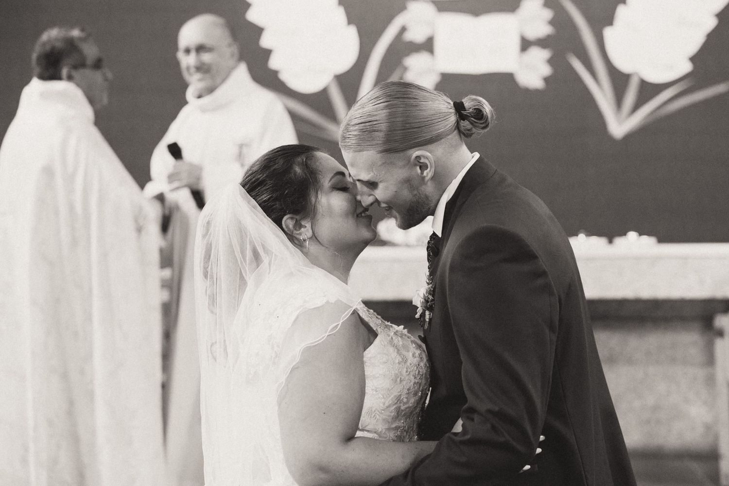 A romantic black and white collage of wedding moments showing couples embracing and kissing at their celebrations.