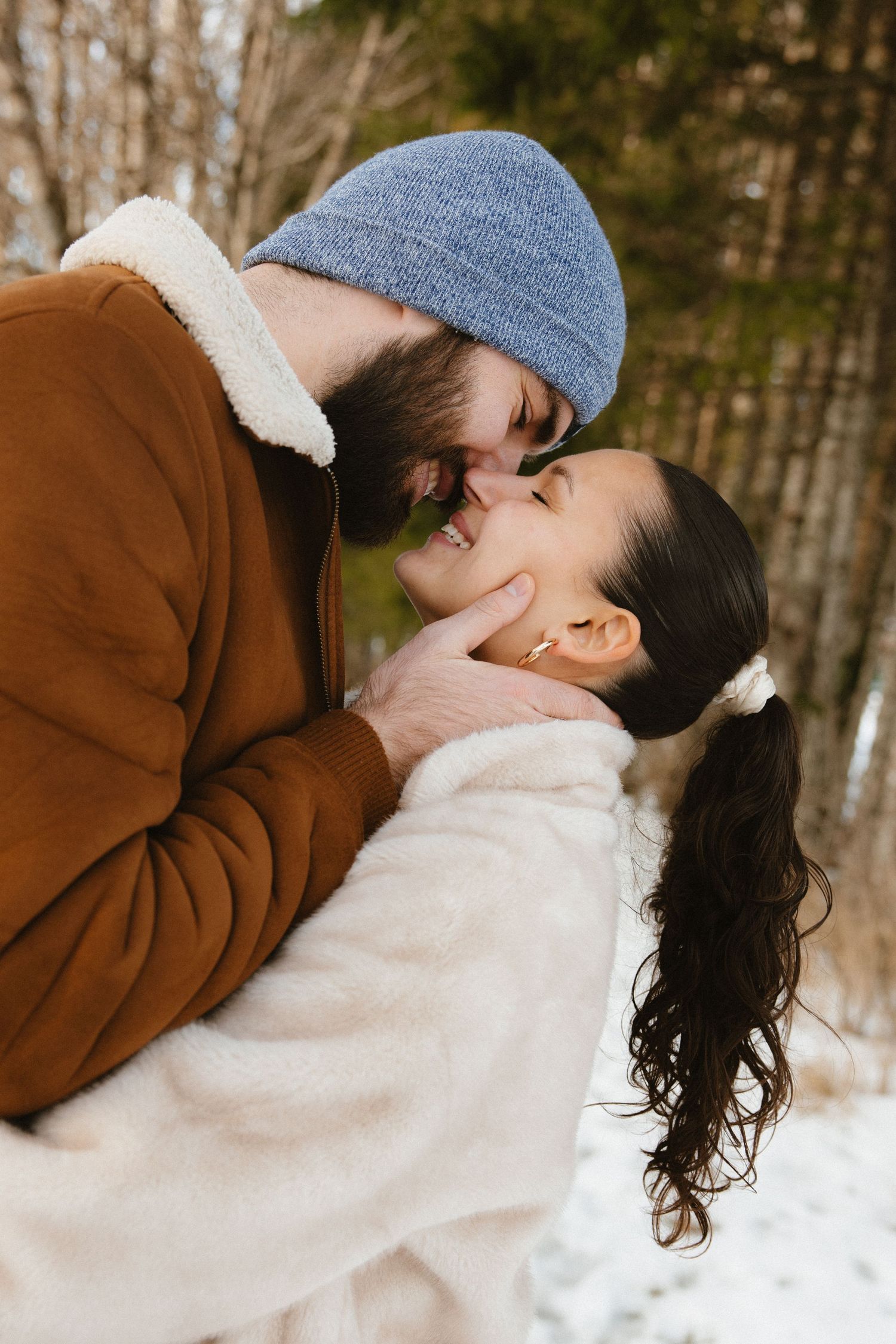 A series of romantic winter photos showing a couple embracing in the snow while wearing cozy winter clothing.