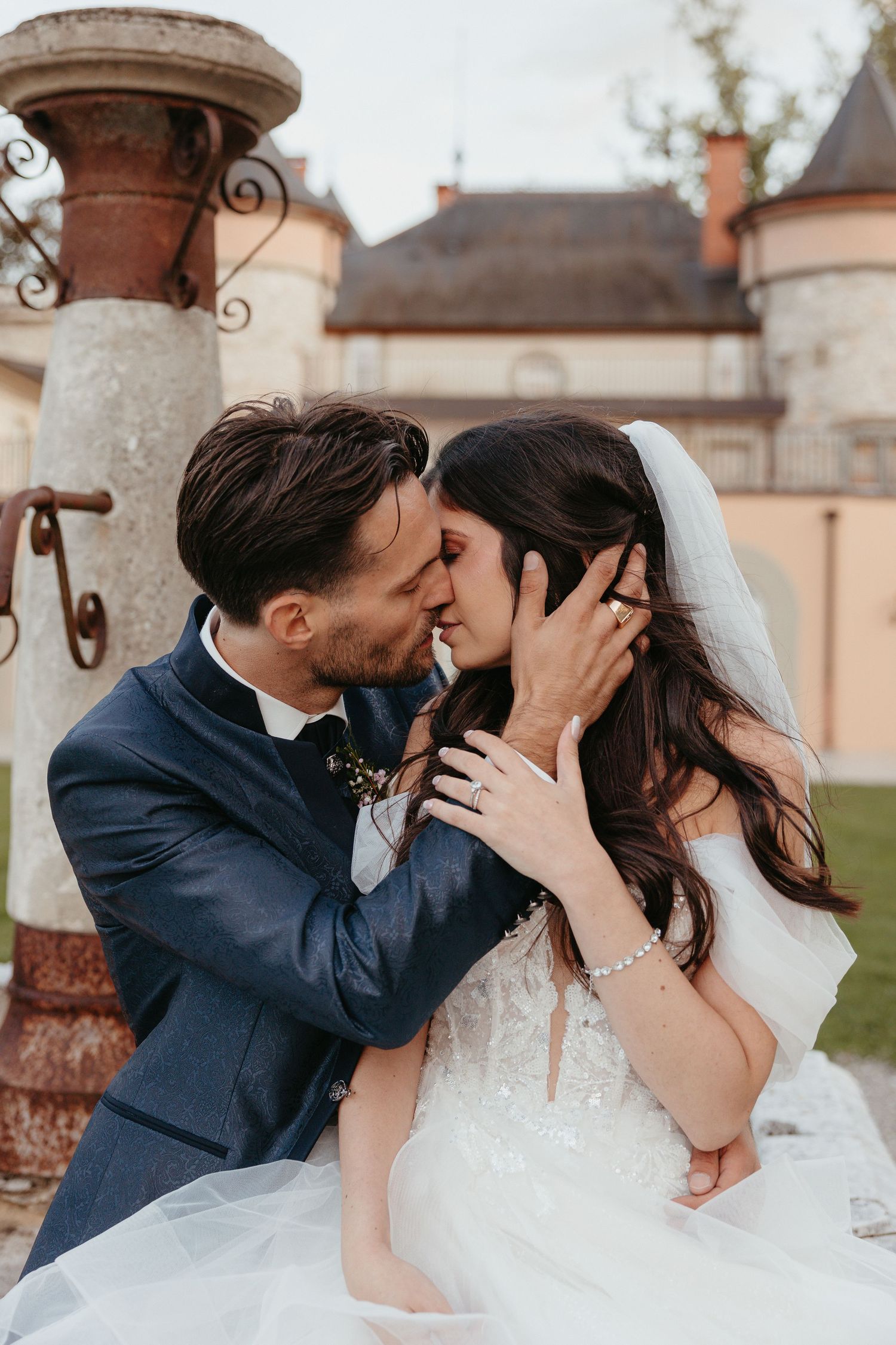 Romantic outdoor wedding photos captured near stone pillars and architecture.