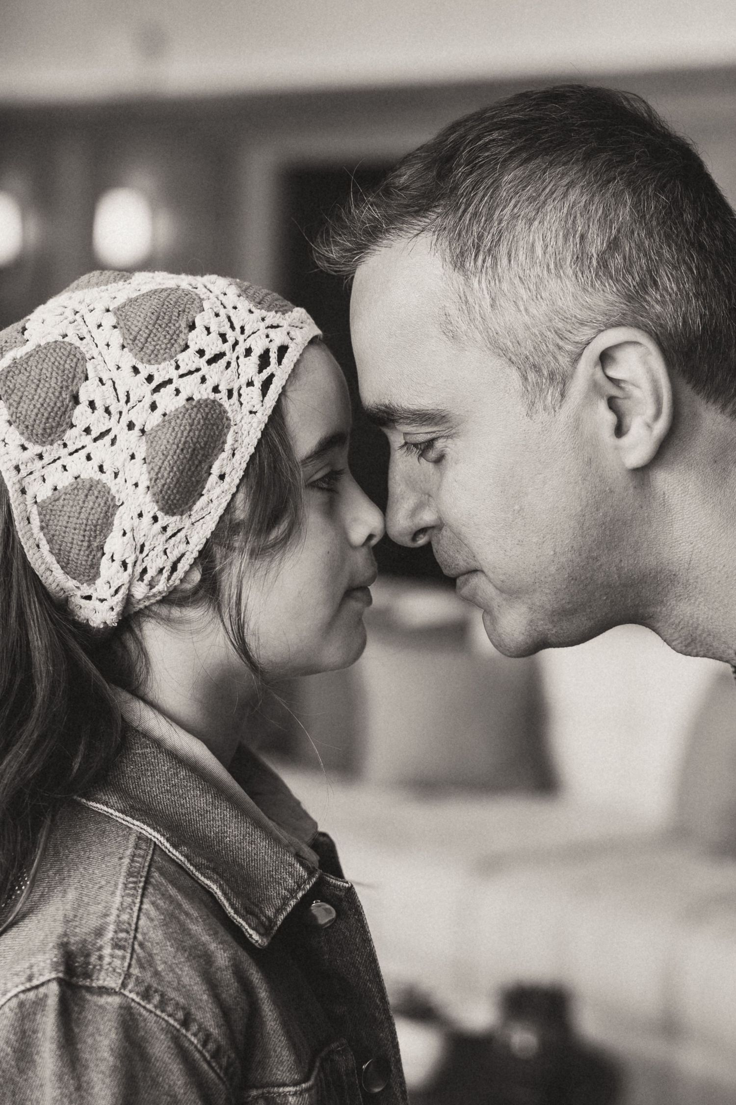 Intimate black and white portrait of couple with woman wearing lace headpiece.