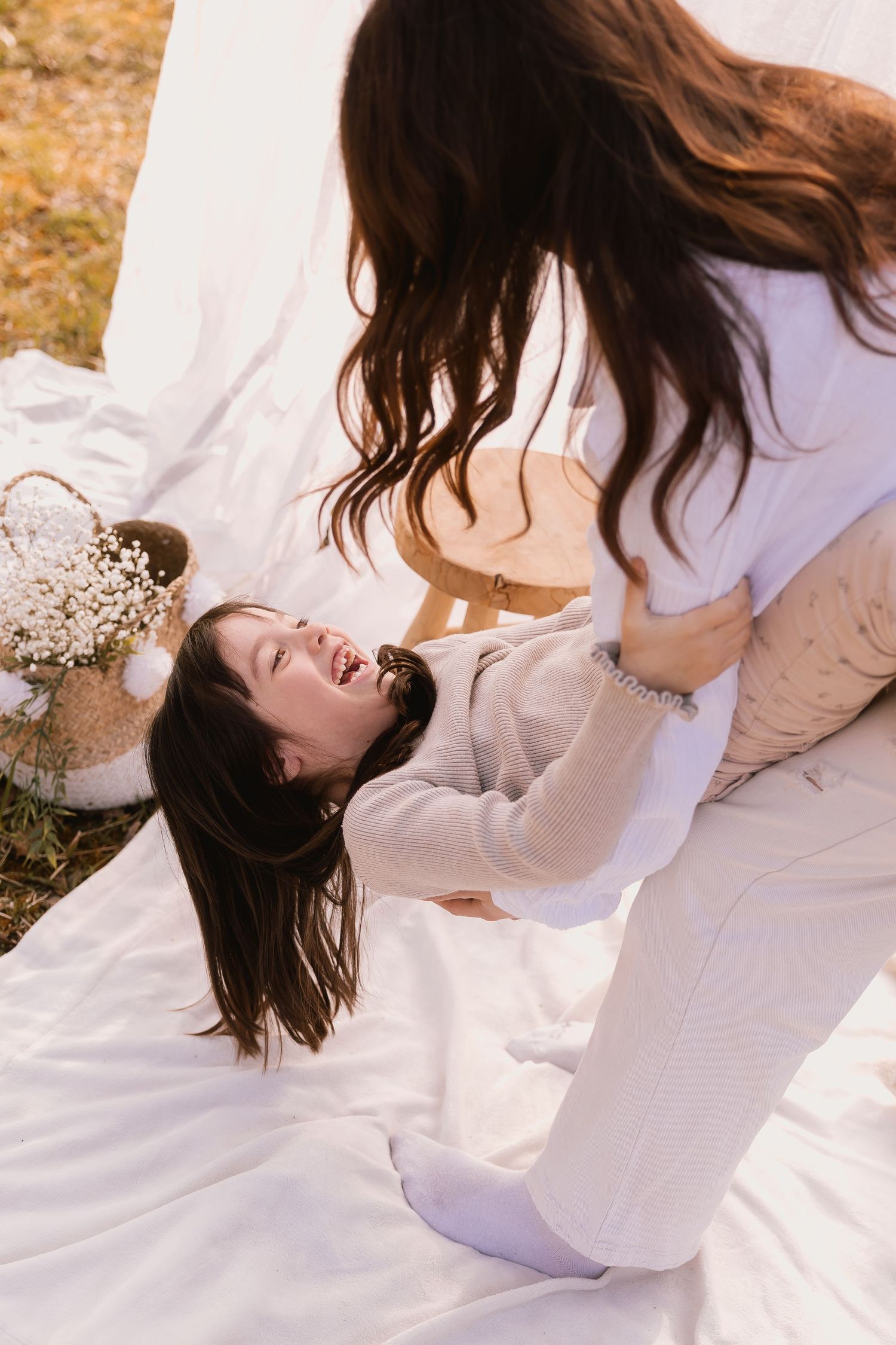 A series of artistic photos showing a person in flowing white clothing lying on a white surface with dreamy ethereal poses.