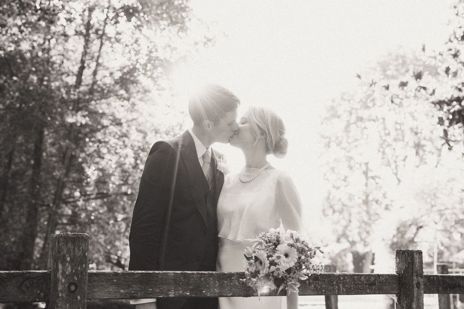 A romantic black and white wedding photo collage showing intimate moments between a couple in an outdoor setting.