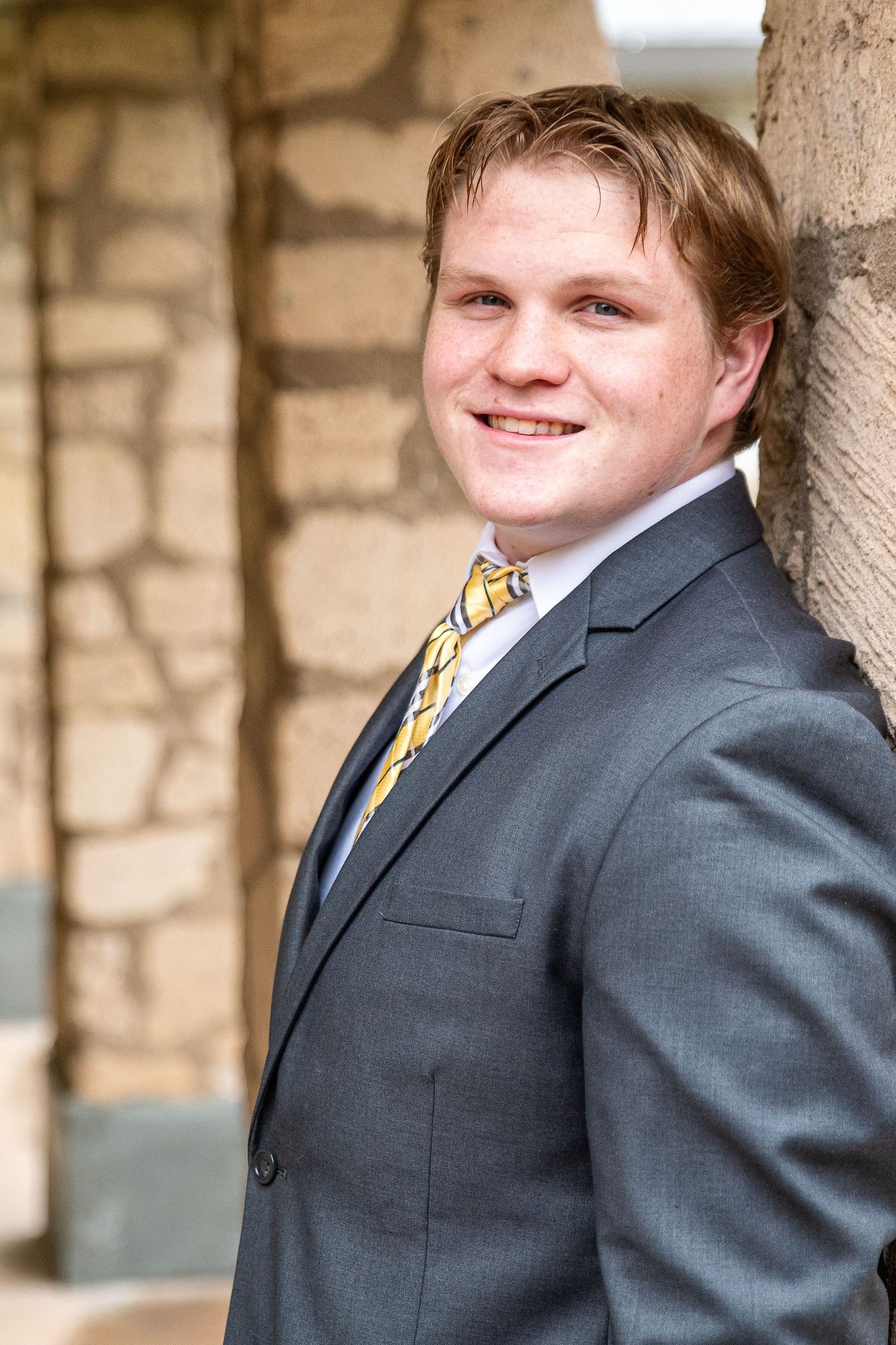 Phoenix high school senior portrait photographer - young man in formal attire at stone column outdoor session
