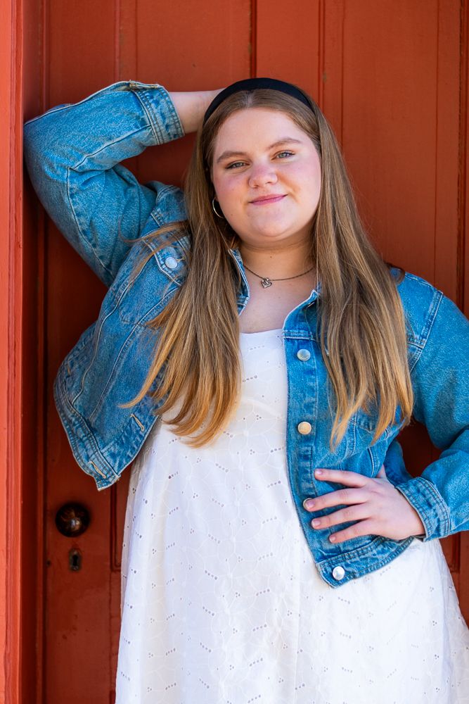 Phoenix high school senior portrait session - girl in denim jacket at red door outdoor location