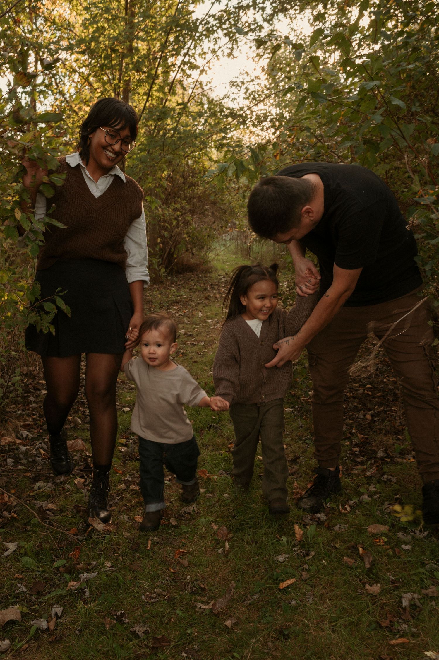 family walking through a forest laughing together