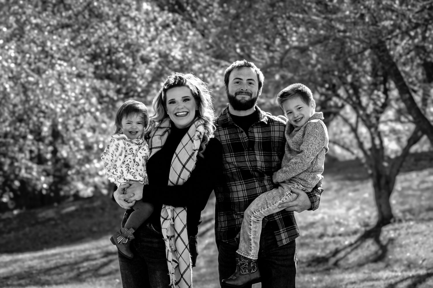 Black and white family portrait series in an outdoor natural setting.