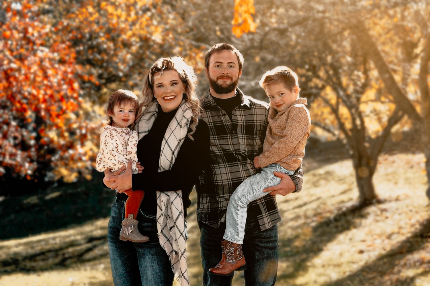 Autumn family photoshoot with warm lighting and fall foliage.