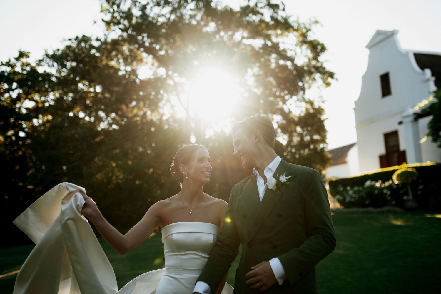 Silhouetted couple dances together in a romantic outdoor setting during golden hour sunset.