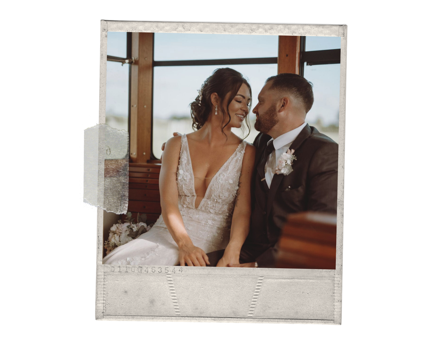 A bride and groom share an intimate moment, smiling at each other in a warmly lit venue on their wedding day.