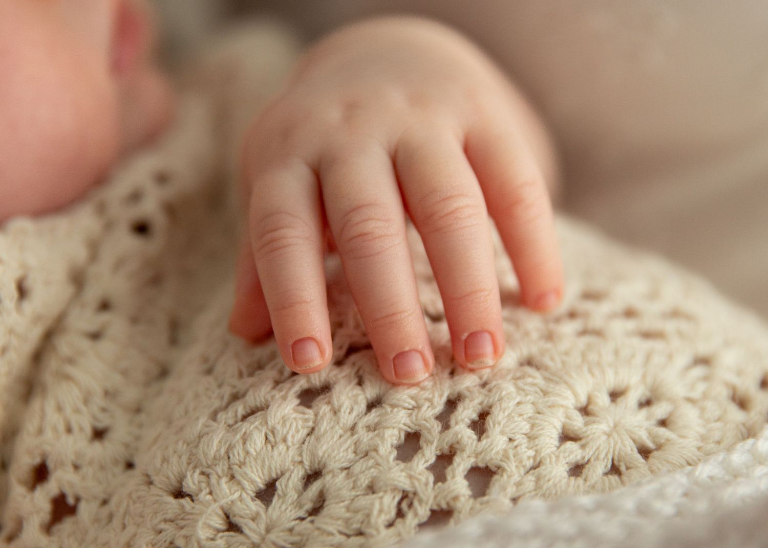 Close up of newborn hand and fingers during natural newborn photohoot in Dubai with soft and natural textures