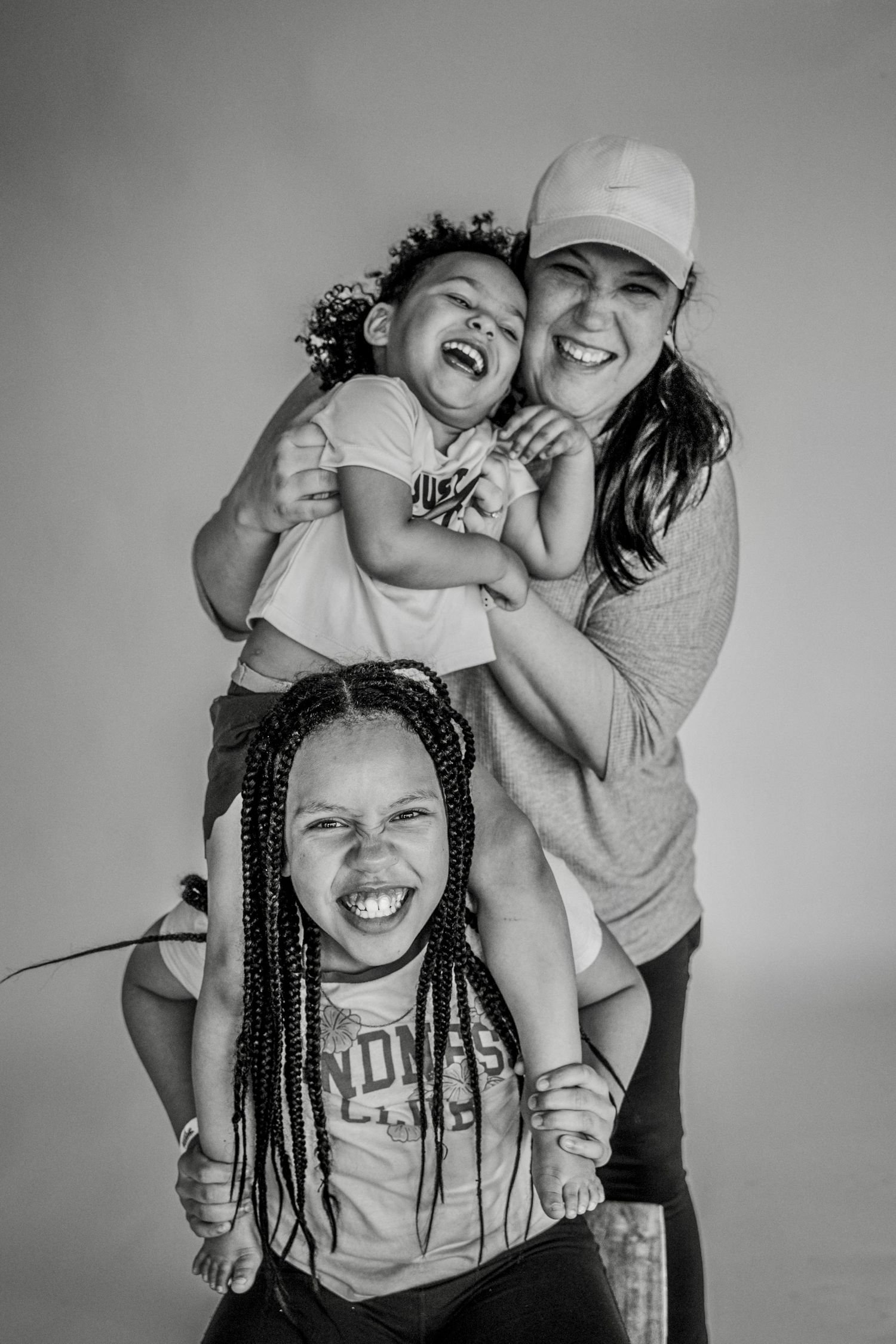 Black and white candid portraits capturing joyful laughter and embraces between two people.