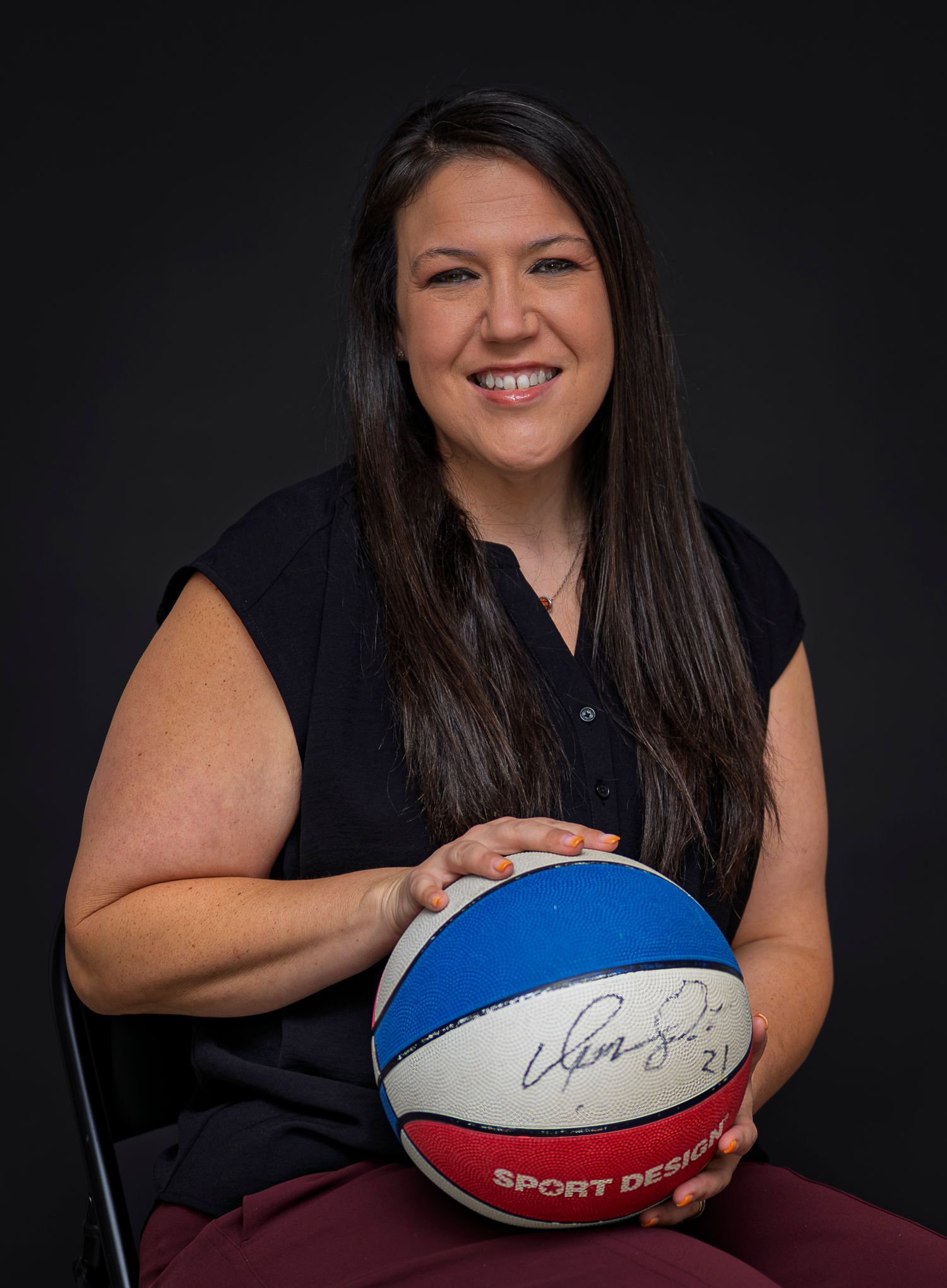 Professional headshot series with rugby ball against dark background.