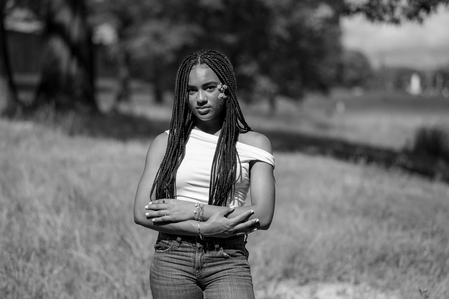 Black and white portrait series in outdoor natural setting with grass field background.