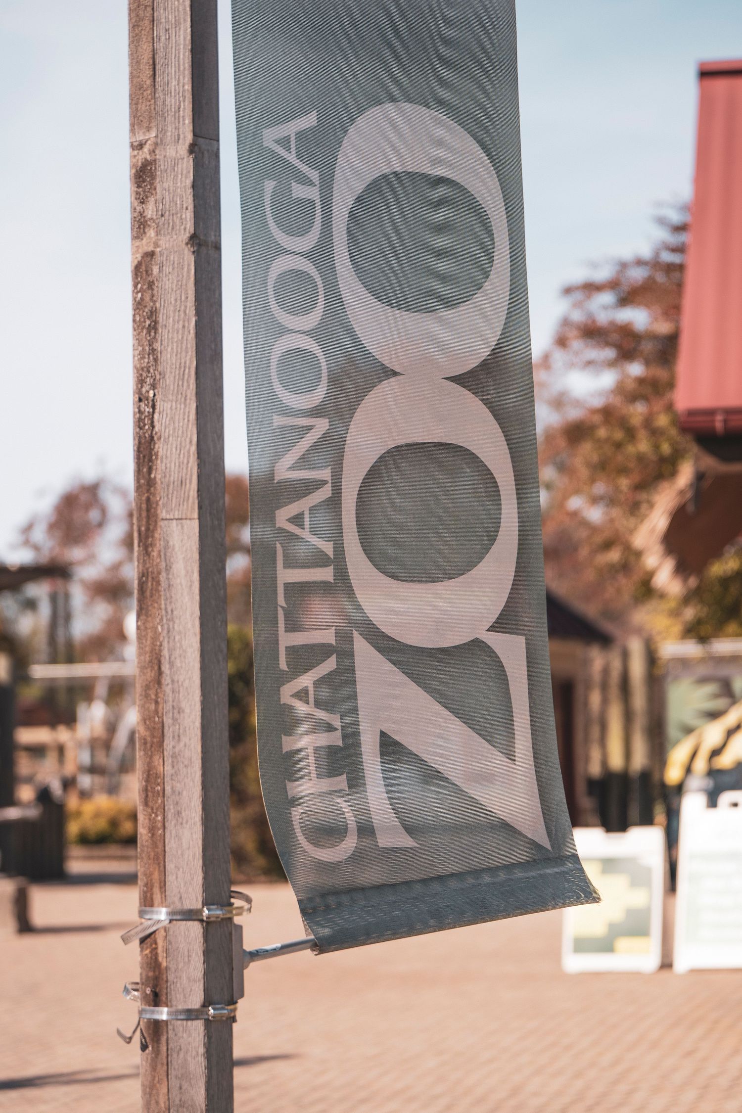 Row of decorative gray banners with text mounted on wooden posts outdoors.