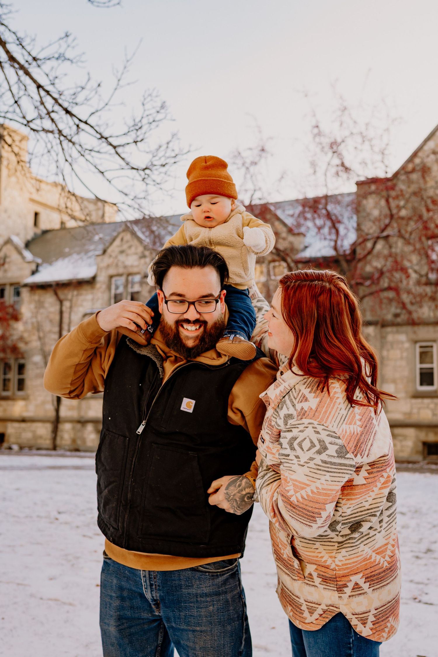 A family shares a joyful moment together outdoors on a snowy winter day wearing cozy sweaters and winter attire.