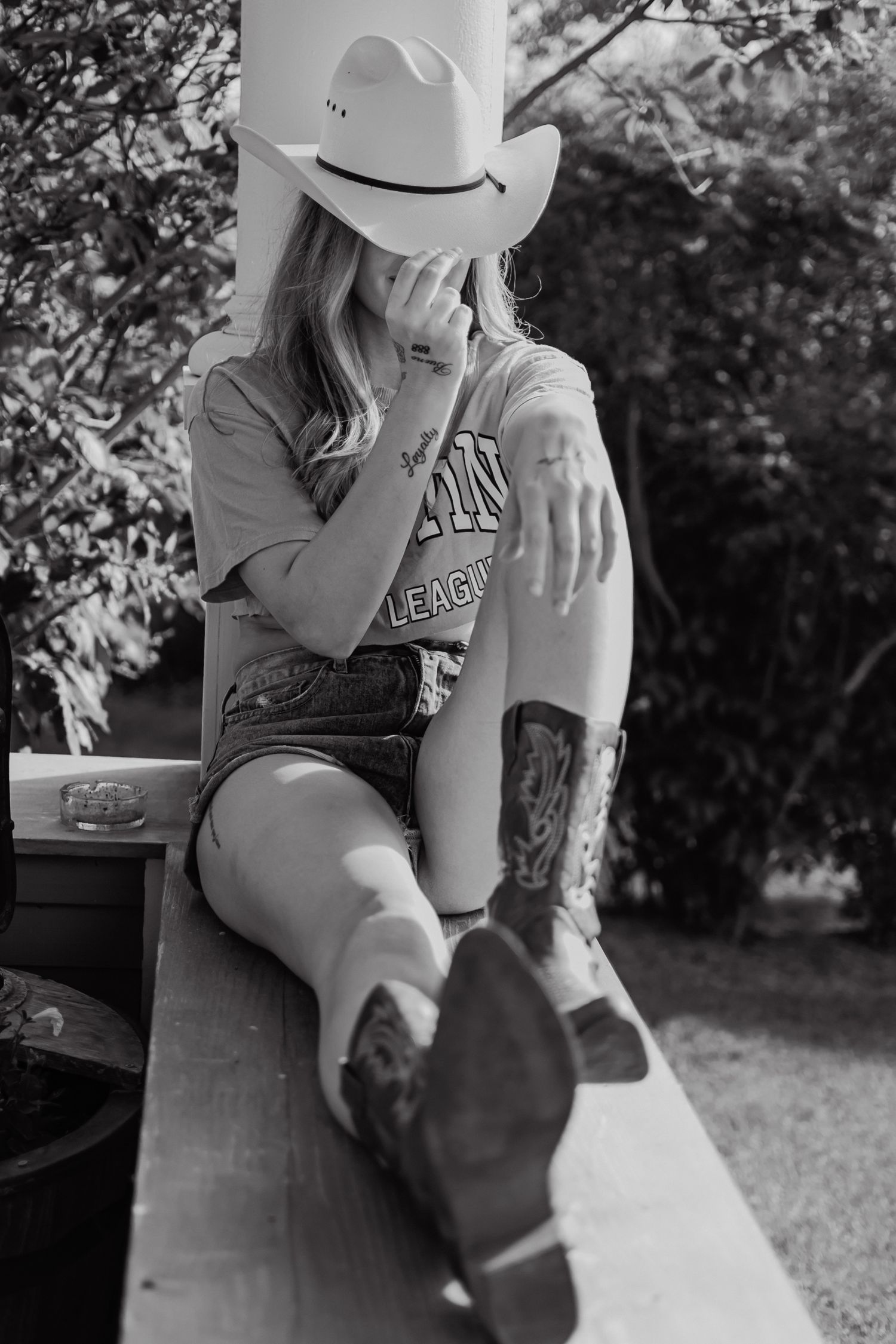 A series of black and white photos showing someone sitting on a bench in an outdoor setting wearing casual attire.