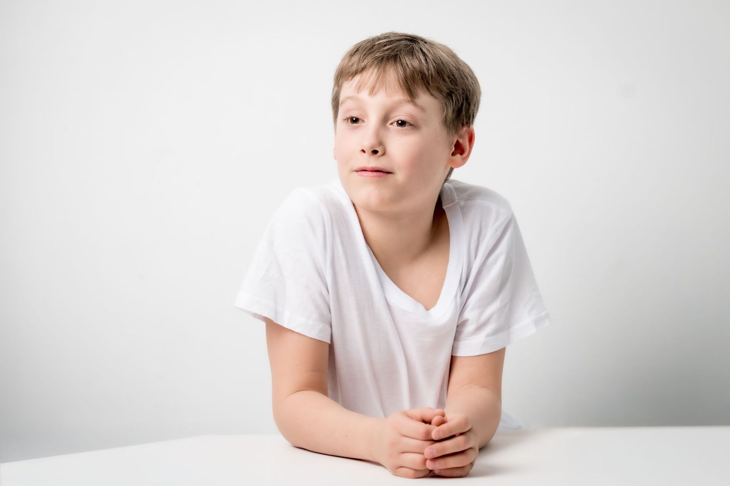 young boy portrait in white background minimalist studio natural expression fine art children photography